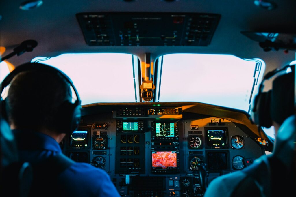 Twee piloten in de cockpit van een verkeersvliegtuig met koptelefoons op