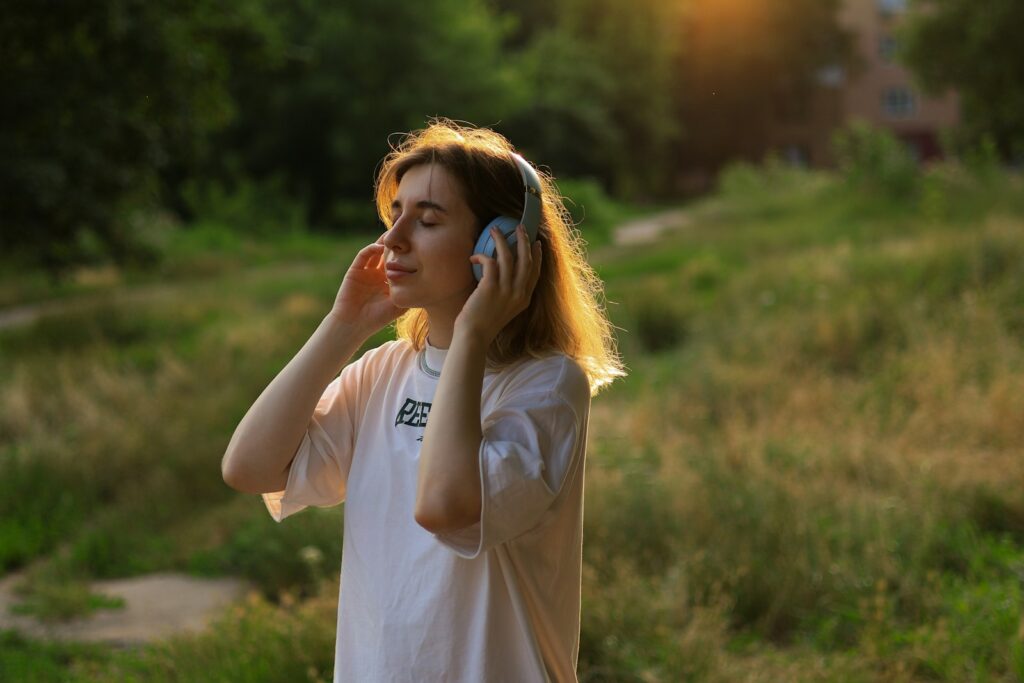 Vrouw met koptelefoon luistert peinzend naar een podcast bij het raam