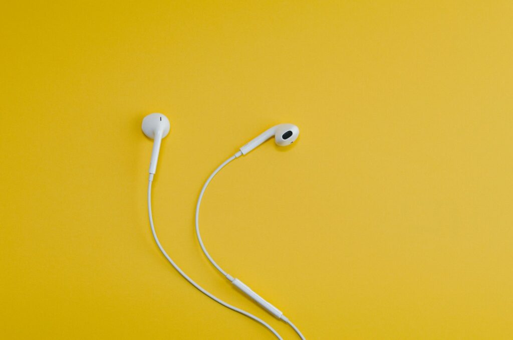 Iemand luistert met een koptelefoon naar een podcast op zijn telefoon