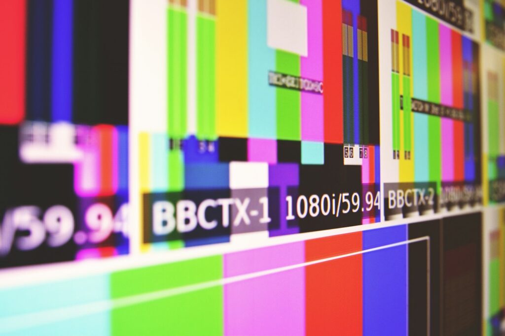 Regieruimte van een televisiestudio met beeldschermen en mengpanelen