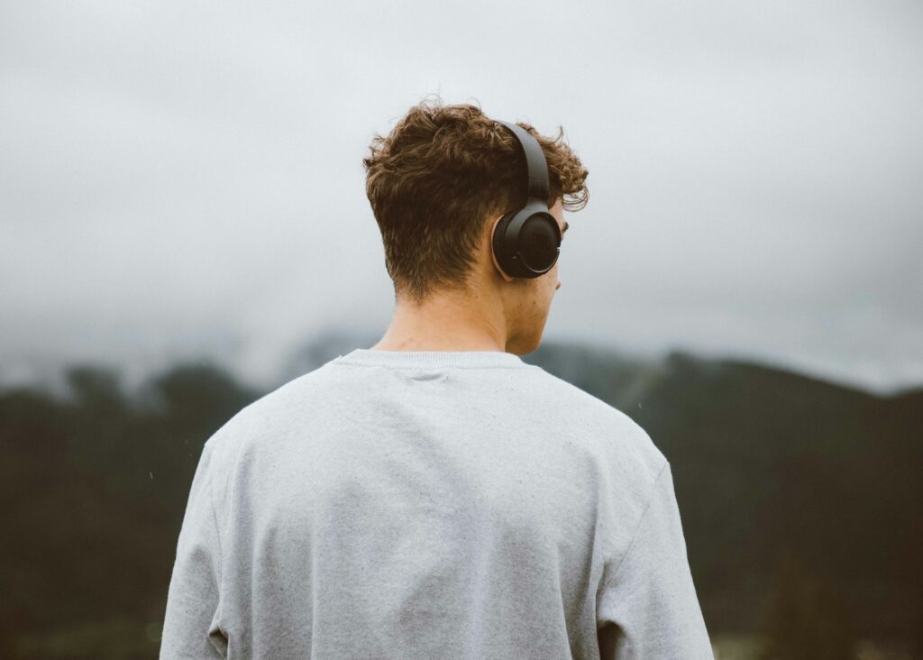 Iemand wandelt buiten met oordopjes in en luistert naar een podcast
